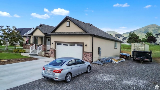 276 N Elk Ridge Dr, Elk Ridge, UT 84651 - view of front of home with stucco siding, a mountain view, driveway, brick siding, and a garage