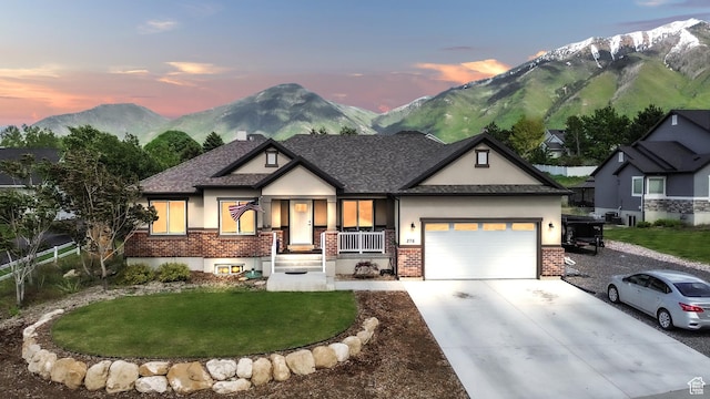 276 N Elk Ridge Dr, Elk Ridge, UT 84651 - view of front of home with stucco siding, brick siding, a garage, driveway, and a mountain view