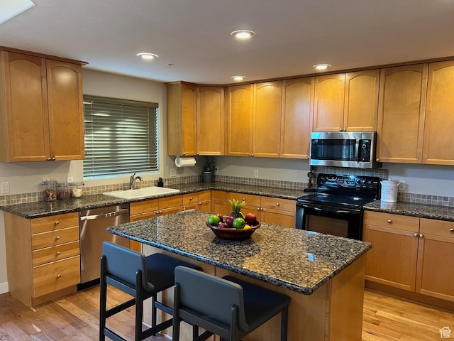 15146 S Walnut Grove Dr, Draper, UT 84020 - kitchen with stainless steel appliances, a sink, light wood-style flooring, a breakfast bar area, and recessed lighting