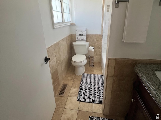 2717 S Orchard Dr, Bountiful, UT 84010 - full bathroom featuring tile walls, vanity, wainscoting, toilet, and tile patterned floors