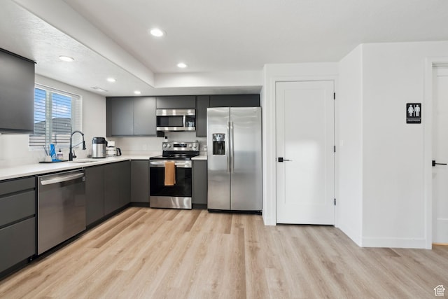 1006 W Firelock Way S, Bluffdale, UT 84065 - kitchen with appliances with stainless steel finishes, light wood-style flooring, gray cabinetry, light countertops, and a sink