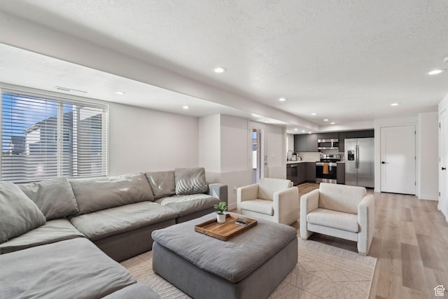 1006 W Firelock Way S, Bluffdale, UT 84065 - living area with light wood-style floors, healthy amount of natural light, recessed lighting, and a textured ceiling