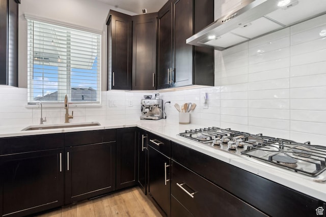 1006 W Firelock Way S, Bluffdale, UT 84065 - kitchen with wall chimney exhaust hood, a sink, stainless steel gas cooktop, tasteful backsplash, and light wood finished floors