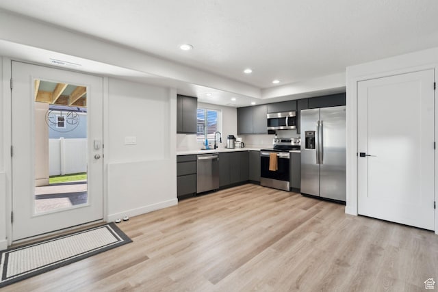 1006 W Firelock Way S, Bluffdale, UT 84065 - kitchen with stainless steel appliances, gray cabinets, light wood-type flooring, a sink, and light countertops