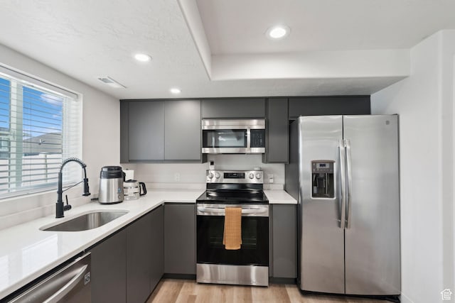 1006 W Firelock Way S, Bluffdale, UT 84065 - kitchen with appliances with stainless steel finishes, a sink, light countertops, gray cabinets, and light wood-type flooring