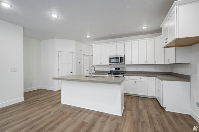 1766 W 160 S Unit 49, Pleasant Grove, UT 84062 - kitchen featuring stainless steel appliances, wood finished floors, recessed lighting, white cabinetry, and a center island with sink