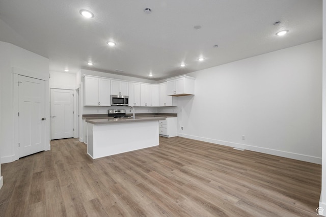 1766 W 160 S Unit 49, Pleasant Grove, UT 84062 - kitchen featuring stainless steel appliances, recessed lighting, light wood finished floors, white cabinetry, and a center island with sink