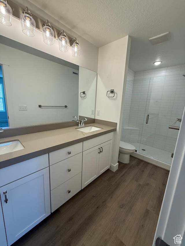 1766 W 160 S Unit 49, Pleasant Grove, UT 84062 - full bath featuring double vanity, wood finished floors, a shower stall, toilet, and a textured ceiling