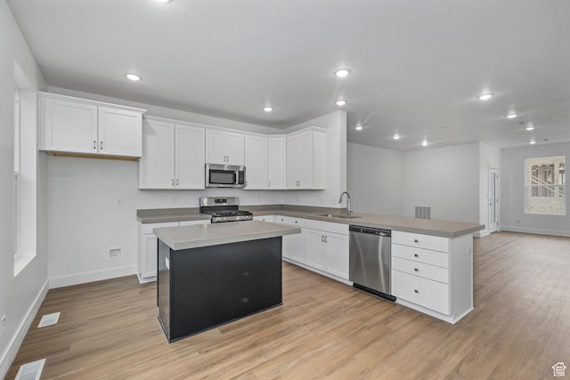 1776 W 160 S Unit 50, Pleasant Grove, UT 84062 - kitchen featuring appliances with stainless steel finishes, a peninsula, light wood-style flooring, white cabinets, and recessed lighting