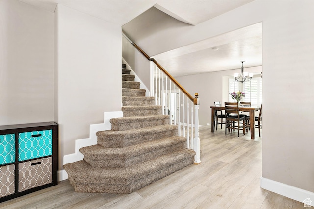 137 Stern Ct, Stansbury Park, UT 84074 - stairway featuring baseboards, wood finished floors, and a chandelier