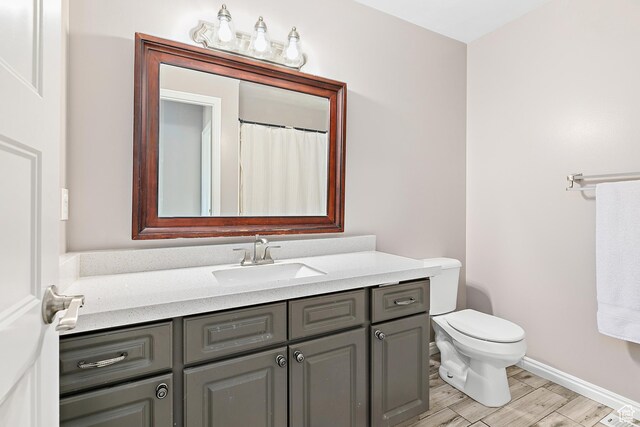137 Stern Ct, Stansbury Park, UT 84074 - bathroom featuring wood finished floors, vanity, toilet, and baseboards