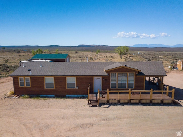 16 E Pearly Ln, La Sal, UT 84530 - view of front of home featuring a deck with mountain view, a shingled roof, and view of desert