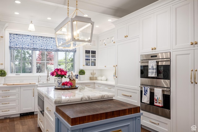 2590 E Olympus Dr, Holladay, UT 84124 - kitchen featuring appliances with stainless steel finishes, a chandelier, butcher block counters, white cabinetry, and a center island