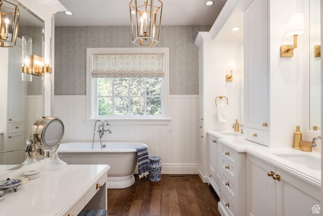 2590 E Olympus Dr, Holladay, UT 84124 - bathroom featuring wood finished floors, a wainscoted wall, wallpapered walls, a freestanding bath, and double vanity