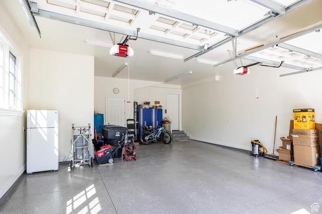2590 E Olympus Dr, Holladay, UT 84124 - garage with freestanding refrigerator, a garage door opener, and baseboards