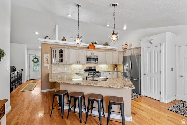 896 E 380 N, Heber City, UT 84032 - kitchen featuring stainless steel appliances, a peninsula, a sink, a kitchen bar, and high vaulted ceiling