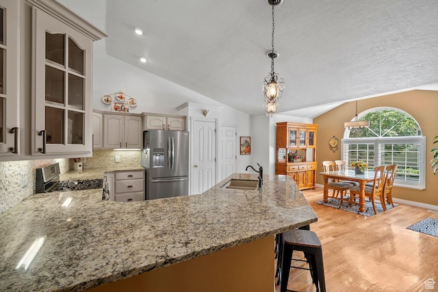 896 E 380 N, Heber City, UT 84032 - kitchen featuring appliances with stainless steel finishes, a sink, lofted ceiling, tasteful backsplash, and light wood-style flooring