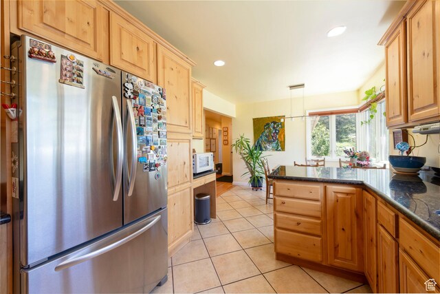 3555 E Hermes Dr S, Salt Lake City, UT 84124 - kitchen featuring freestanding refrigerator, white microwave, light tile patterned floors, a peninsula, and dark stone countertops