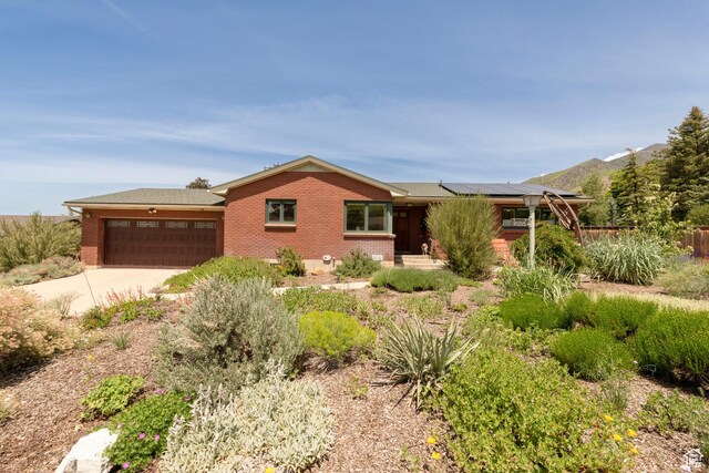 3555 E Hermes Dr S, Salt Lake City, UT 84124 - ranch-style home with brick siding, an attached garage, solar panels, and concrete driveway