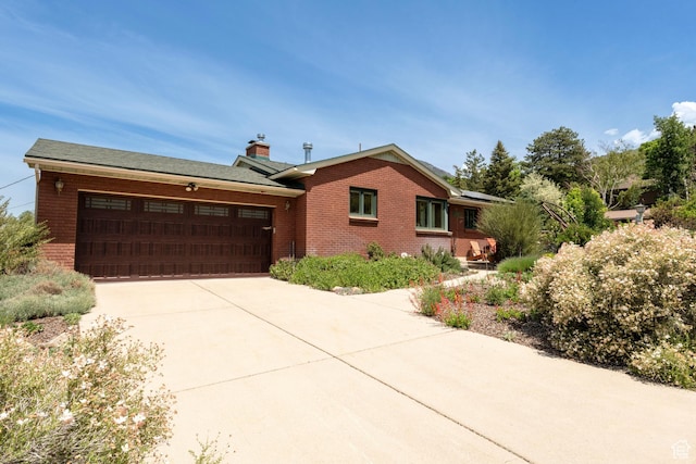 3555 E Hermes Dr S, Salt Lake City, UT 84124 - ranch-style house featuring an attached garage, driveway, solar panels, brick siding, and a chimney