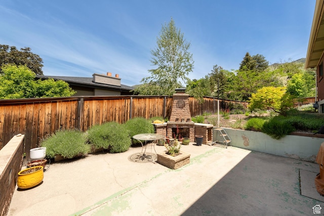 3555 E Hermes Dr S, Salt Lake City, UT 84124 - fenced backyard with an outdoor stone fireplace and a patio