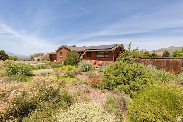 3555 E Hermes Dr S, Salt Lake City, UT 84124 - back of property featuring solar panels, brick siding, and a mountain view