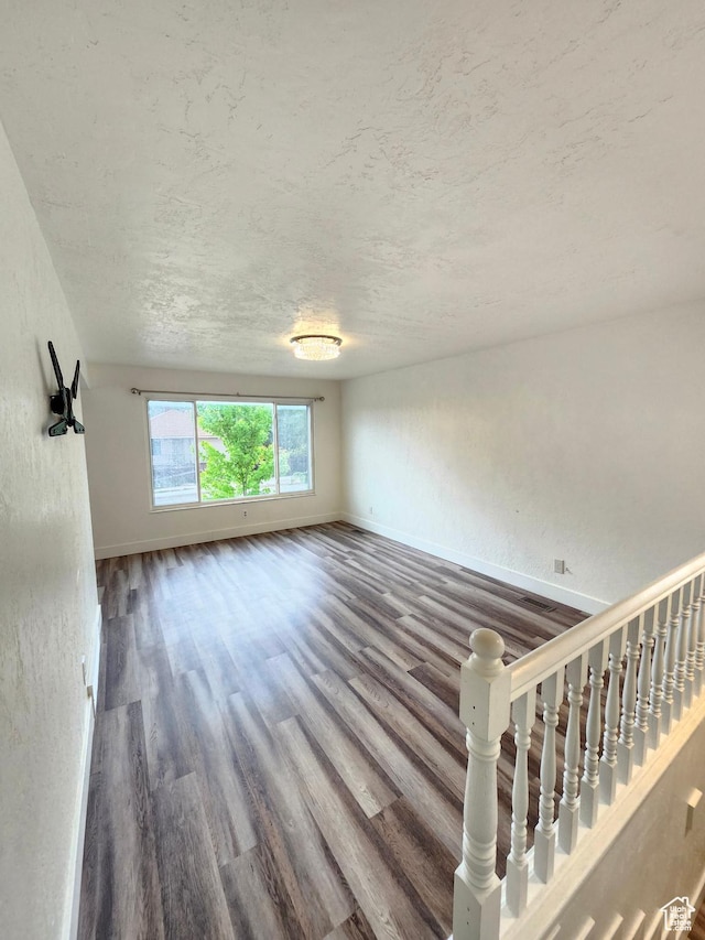 317 S 200 W, Price, UT 84501 - unfurnished living room with wood finished floors, baseboards, and a textured ceiling