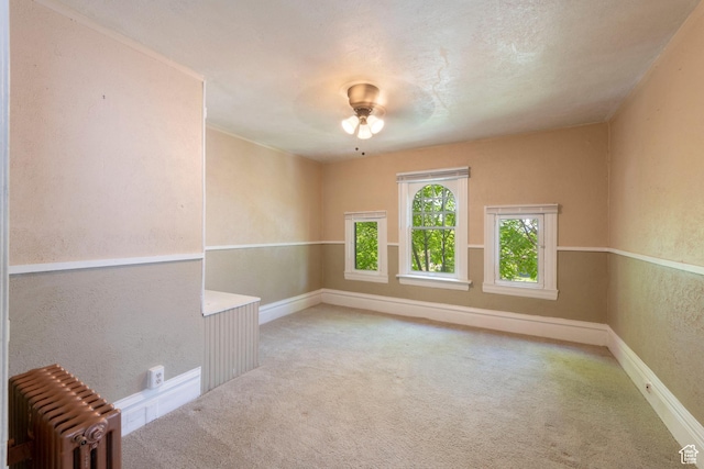 237 S 1100 E, Salt Lake City, UT 84102 - empty room featuring radiator, carpet flooring, a textured wall, and baseboards