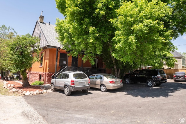 237 S 1100 E, Salt Lake City, UT 84102 - obstructed view of property with a shingled roof, brick siding, and a chimney