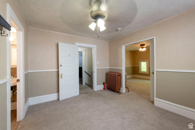 237 S 1100 E, Salt Lake City, UT 84102 - unfurnished bedroom with radiator heating unit, carpet, ceiling fan, and baseboards