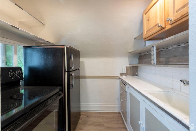 237 S 1100 E, Salt Lake City, UT 84102 - kitchen with black electric range oven, light countertops, baseboards, light wood-type flooring, and backsplash
