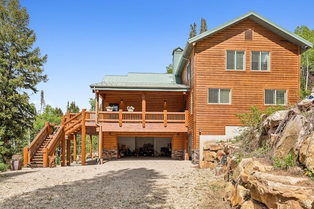 4708 Red Fir Way, Oakley, UT 84055 - rear view of property featuring an attached garage, gravel driveway, stairs, and metal roof