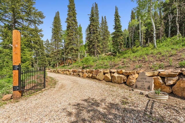 4708 Red Fir Way, Oakley, UT 84055 - view of dirt / gravel driveway featuring a gate, a view of trees, and a gated entry
