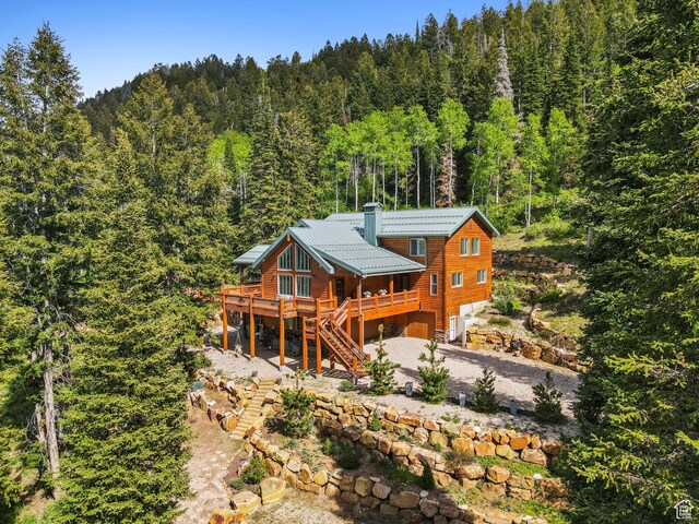 4708 Red Fir Way, Oakley, UT 84055 - back of property with a forest view, stairs, a garage, gravel driveway, and a deck