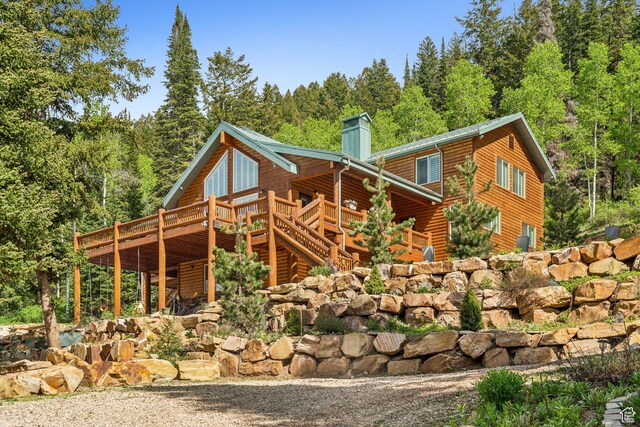 4708 Red Fir Way, Oakley, UT 84055 - view of side of property with a wooden deck, a chimney, log veneer siding, and a view of trees