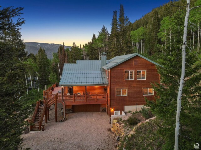 4708 Red Fir Way, Oakley, UT 84055 - back of property at dusk with a forest view, gravel driveway, metal roof, and stairway