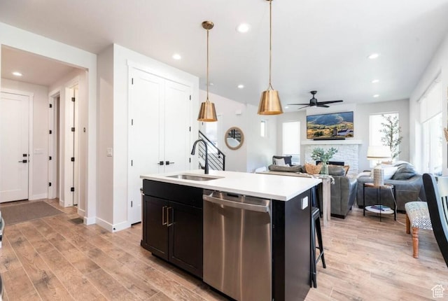 12852 N Belaview Way, Hideout, UT 84036 - kitchen featuring stainless steel dishwasher, a sink, light wood finished floors, light countertops, and a center island with sink