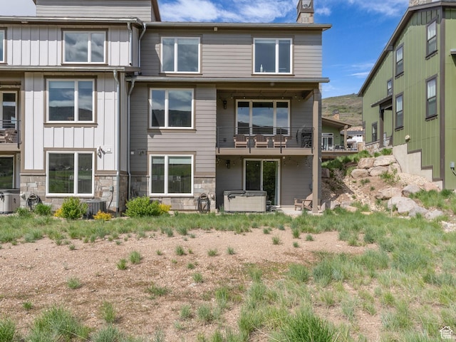 12852 N Belaview Way, Hideout, UT 84036 - rear view of house with board and batten siding, a chimney, stone siding, and a balcony