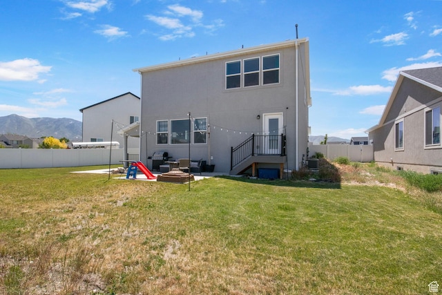 432 W 1470 N, Tooele, UT 84074 - back of house with a patio area, a fenced backyard, a mountain view, and stucco siding