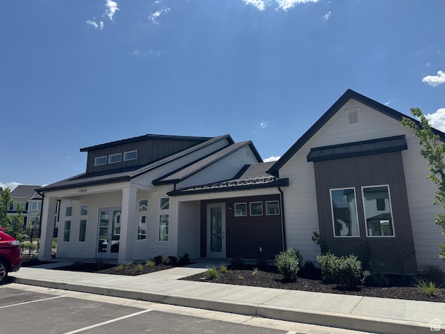4569 W Ruple Ridge Ln S, Herriman, UT 84096 - view of front facade featuring board and batten siding, uncovered parking, and french doors