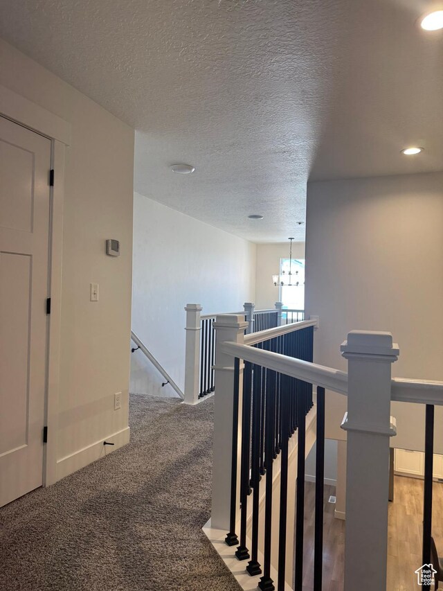 4569 W Ruple Ridge Ln S, Herriman, UT 84096 - hall featuring an upstairs landing, baseboards, recessed lighting, a textured ceiling, and a chandelier
