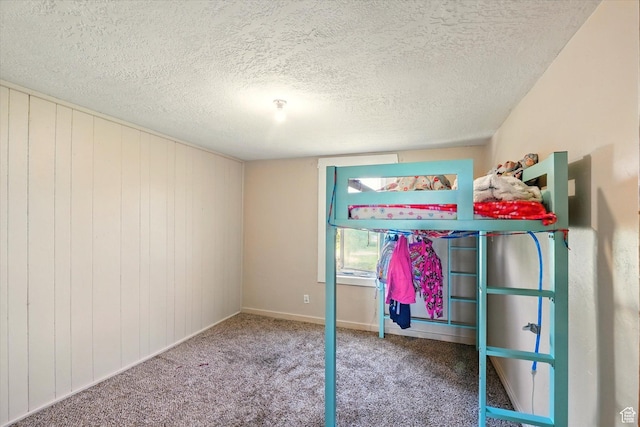 1411 E 13000 N, Cove, UT 84320 - unfurnished bedroom with a textured ceiling, carpet, baseboards, and wooden walls