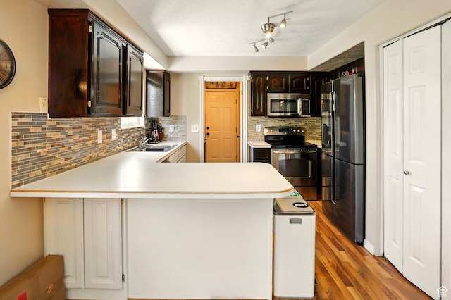 2223 S Allison Way, Syracuse, UT 84075 - kitchen with appliances with stainless steel finishes, a peninsula, light countertops, backsplash, and a sink