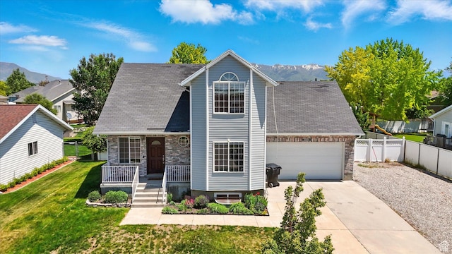 2223 S Allison Way, Syracuse, UT 84075 - view of front facade with covered porch, driveway, stone siding, and a mountain view