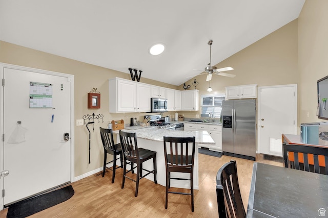 1127 W Monticello Ln, Murray, UT 84123 - kitchen with stainless steel appliances, a sink, a peninsula, white cabinets, and high vaulted ceiling