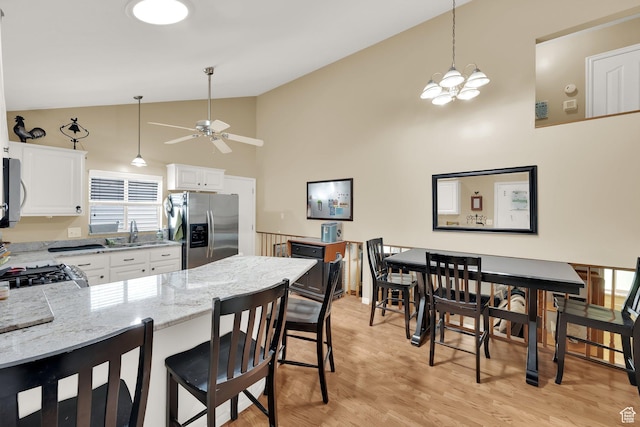1127 W Monticello Ln, Murray, UT 84123 - kitchen with stainless steel fridge, light stone counters, ceiling fan, a peninsula, and light wood finished floors