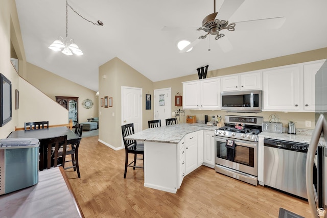 1127 W Monticello Ln, Murray, UT 84123 - kitchen with stainless steel appliances, a ceiling fan, a peninsula, a kitchen bar, and lofted ceiling
