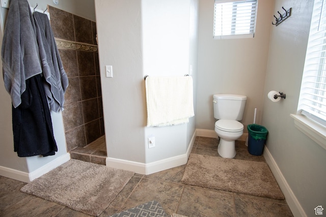 286 E 850 N, Richfield, UT 84701 - bathroom featuring toilet, plenty of natural light, tiled shower, and baseboards