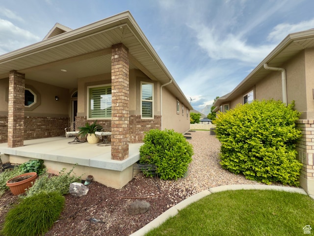 3322 N 750 E, Lehi, UT 84043 - view of side of property with stucco siding, a porch, and brick siding