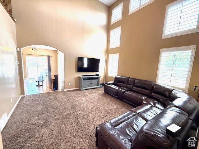 1093 S 1960 E, Spanish Fork, UT 84660 - carpeted living area with a high ceiling, arched walkways, and baseboards